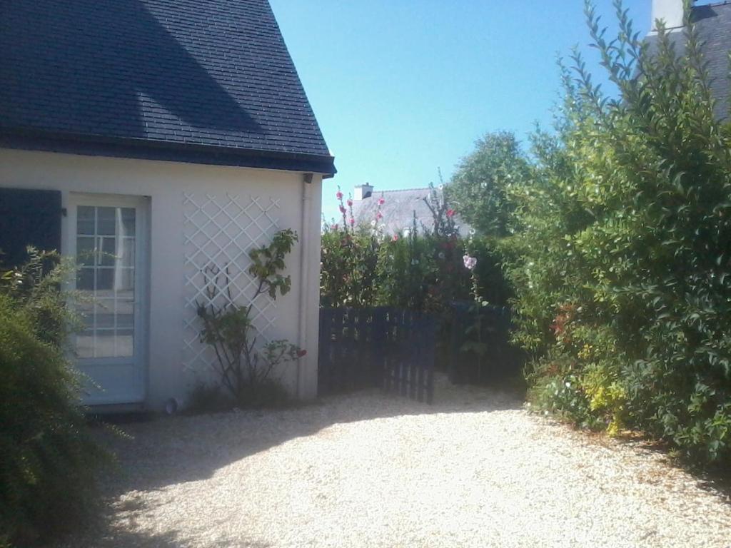 ein weißes Haus mit einem Zaun und einem Hof in der Unterkunft Vacances à Erdeven in Erdeven
