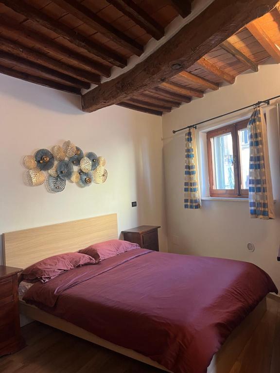 1 dormitorio con cama y ventana en grazioso appartamento Pisa sull’Arno en Pisa