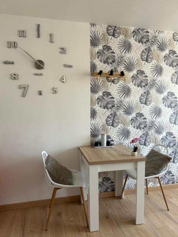 a room with a table and a clock on the wall at AIGLON in Roquebrune-Cap-Martin