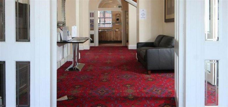 uma sala de estar com um sofá e um tapete vermelho em The Knighton Hotel - Full House em Knighton