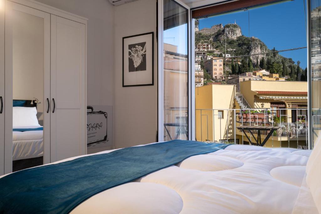 una camera con un grande letto e un balcone di SARA GUEST HOUSE TAORMINA a Taormina