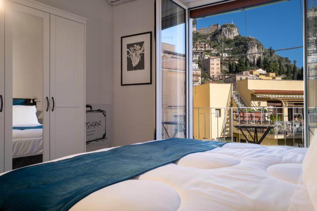 a bedroom with a large bed and a balcony at SARA GUEST HOUSE TAORMINA in Taormina