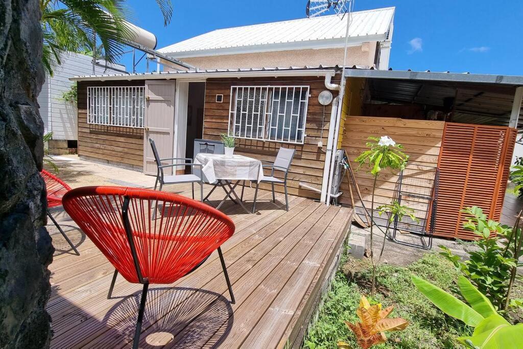 a wooden deck with a table and chairs on it at Ti Caz Emma in La Possession