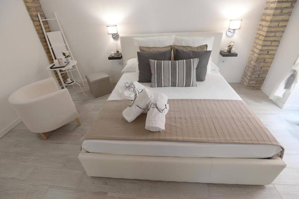 a bedroom with a large white bed with towels on it at Il Mattoncino - Colosseo in Rome