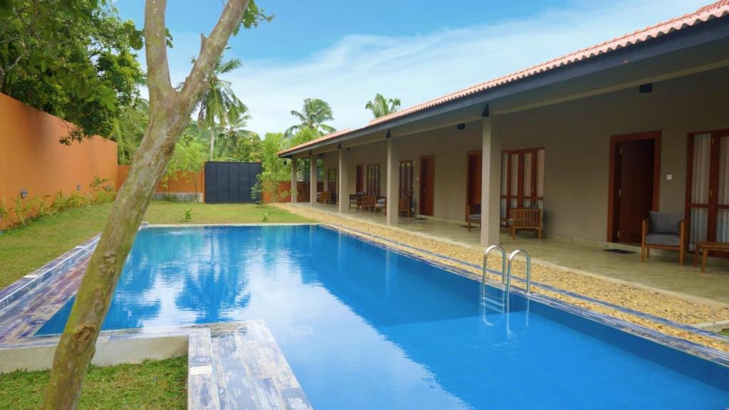 a swimming pool in front of a house at Diyathra Escape in Galle