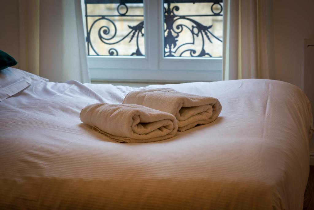 a towel sitting on top of a bed with a window at L Axelle magnifique F4 plein centre de Rouen ! in Rouen