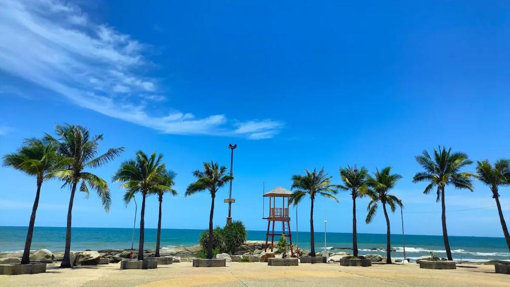 a lifeguard tower on a beach with palm trees at BEACH FRONT modern room + Free hi speed Wi-Fi in Ban Chak Phai