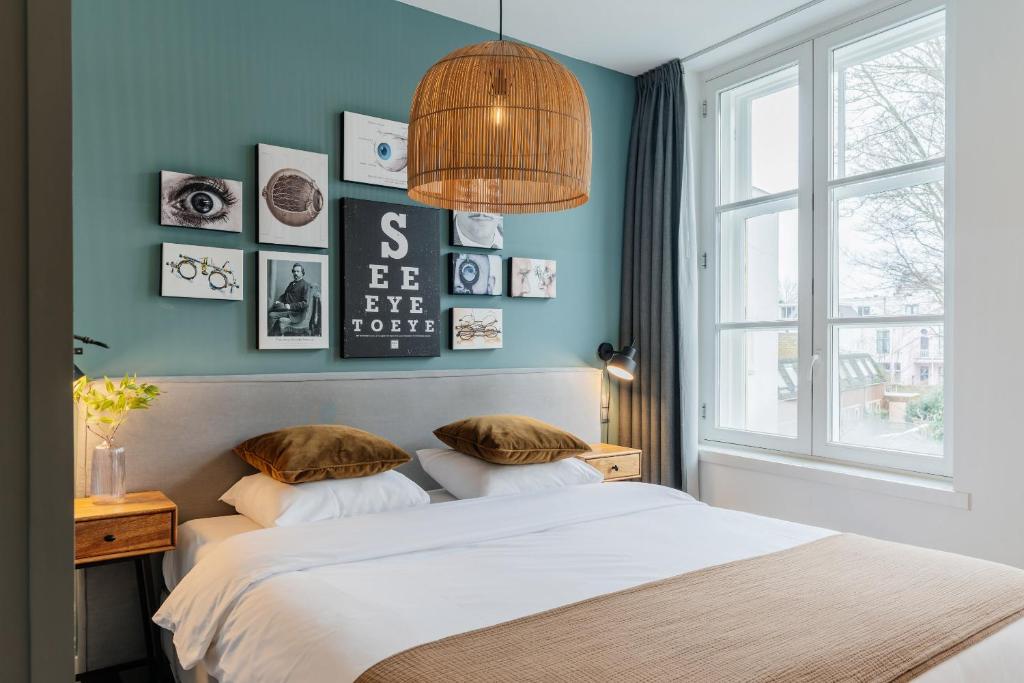 a bedroom with blue walls and a bed with pillows at Eye Hotel in Utrecht