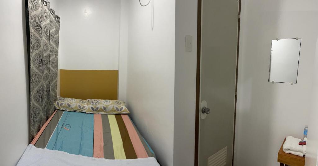 een kleine kamer met een bed in de hoek bij Calo apartel in Panabo