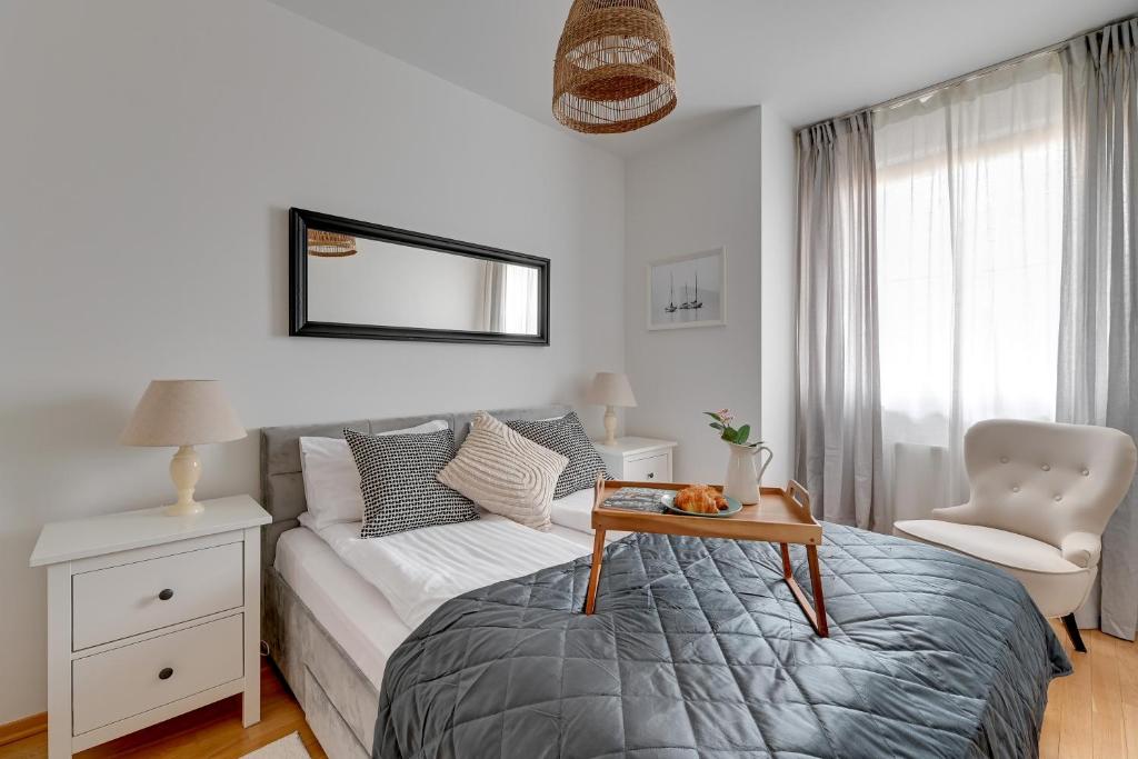 a bedroom with a bed and a table and a chair at Lion Apartments - Amalfi Quiet Family 3 Bedr Apartment in Sopot