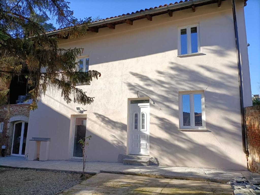 uma casa branca com uma porta branca e janelas em La dimora del capitano em Quattordio