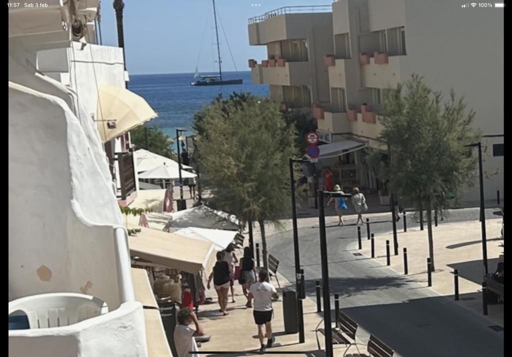 a group of people walking down a sidewalk near the ocean at Es Pujols Vista Mare in Es Pujols
