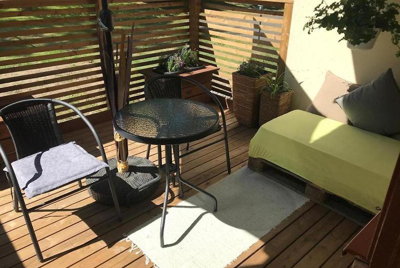 a balcony with a table and a chair on a deck at Apartment Nilsiä in Kuopio
