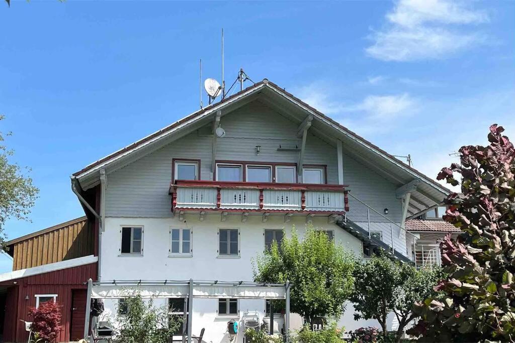 Casa blanca con balcón en la parte superior. en Ferienwohnung am Bauernhof, en Wald