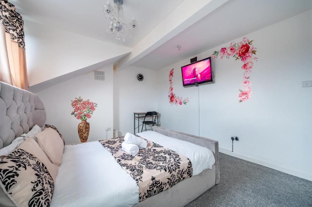 a bedroom with a bed and a tv on the wall at *RA60G* For your most relaxed & Cosy stay + Free Parking + Free Fast WiFi * in Morley
