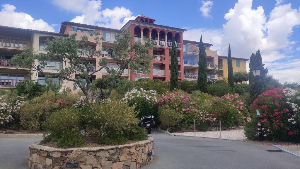 un bâtiment avec un bouquet de fleurs devant dans l'établissement Les Issambres, résidence standing - T3 Magnifique Vue Mer-Piscine Ste Maxime 7km, à Roquebrune-sur Argens