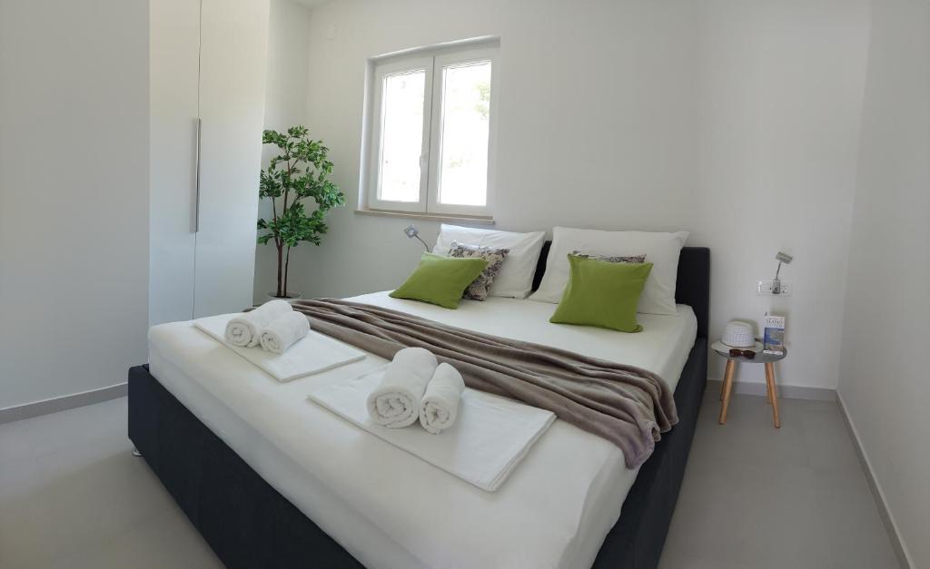 a bedroom with a large bed with towels on it at Slano Bay Apartments in Slano