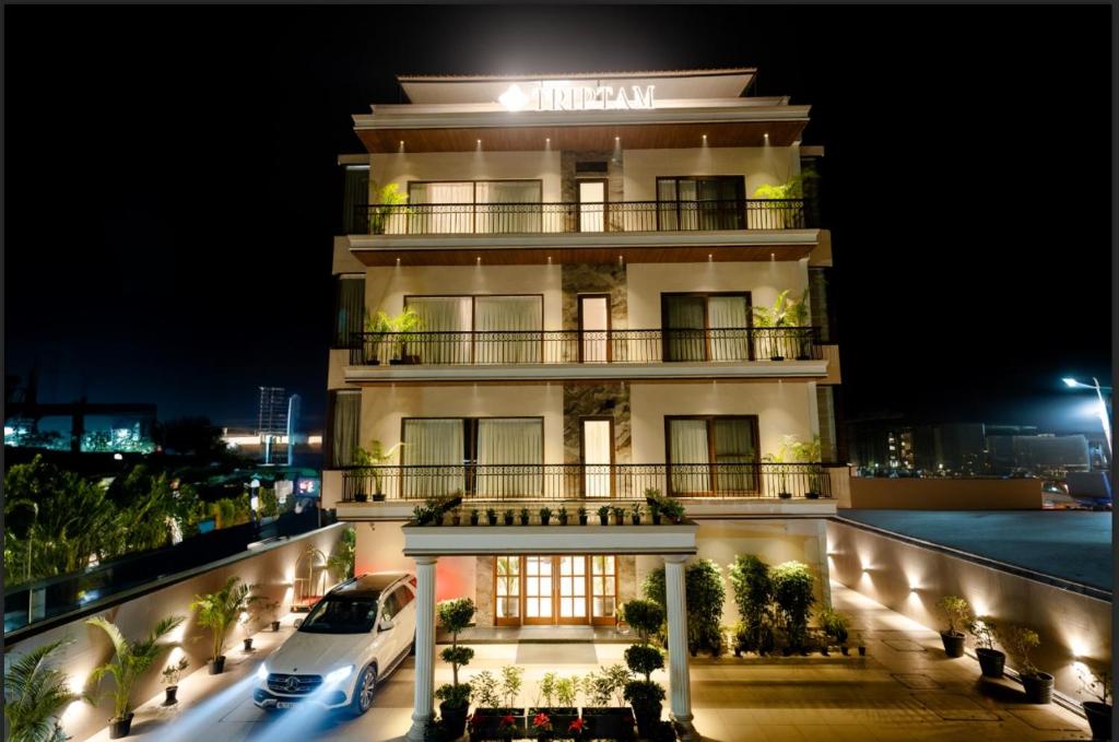 a building with a car parked in front of it at Triptam Vrindavan in Vrindāvan