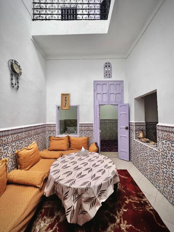 Riad Yamna في الرباط: غرفة معيشة مع أريكة وطاولة