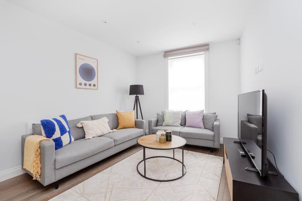 uma sala de estar com um sofá e uma mesa em Modern House in South Kensington em Londres