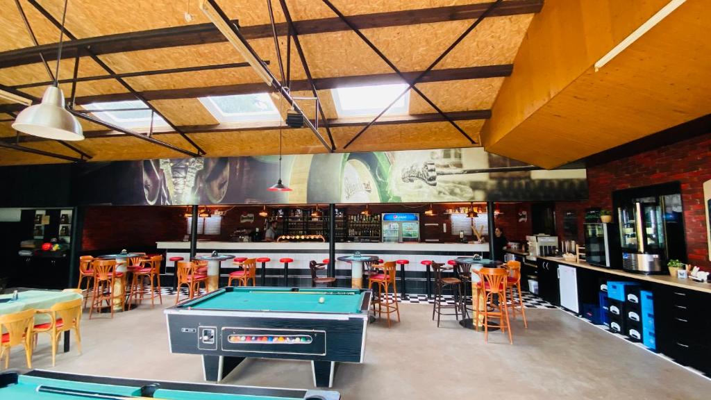 un bar con tavolo da ping pong e sedie di Chatový areál Zděřina a Police nad Metují