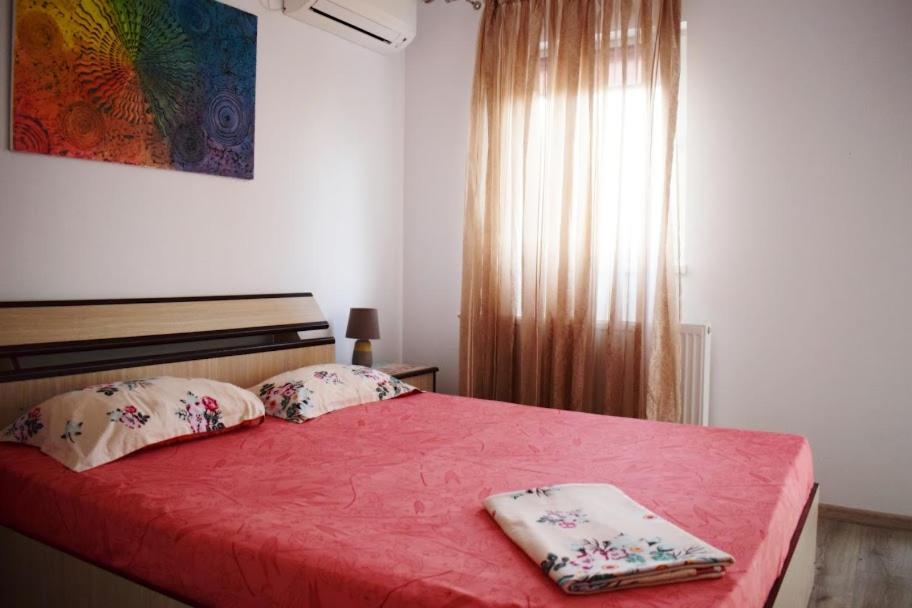ein Schlafzimmer mit einem roten Bett mit zwei Kissen darauf in der Unterkunft Vila Aliss in Mamaia Nord – Năvodari