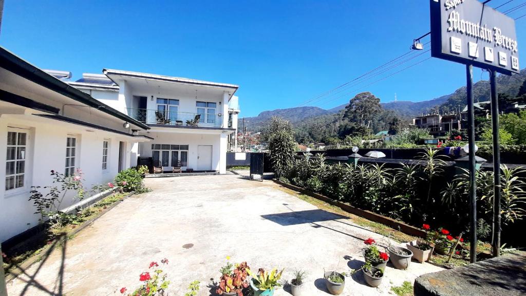 un bâtiment avec beaucoup de plantes en pot dans une cour dans l'établissement Sapu's Mountain breeze Nuwara Eliya, à Nuwara Eliya