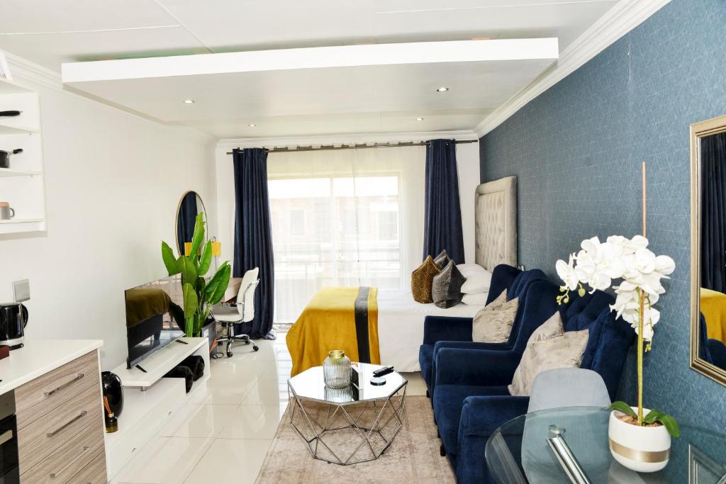 a blue and white living room with a blue couch at Eirini Elegant - Rispetto Apartment with Power Backup in Midrand