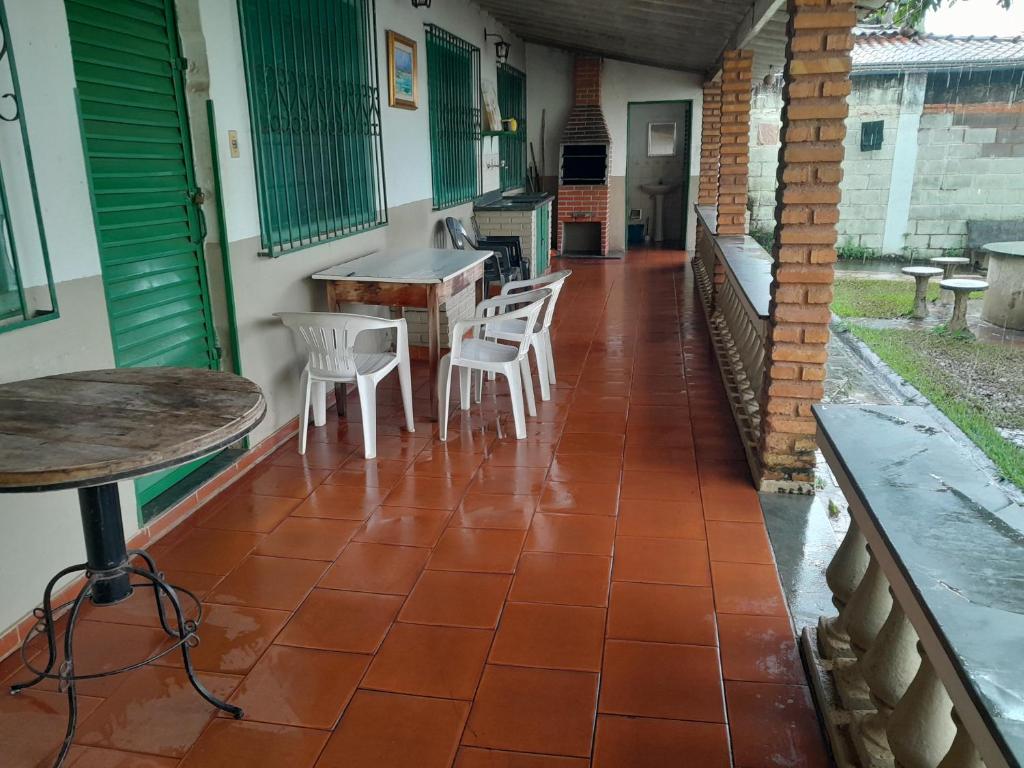 eine Terrasse mit Stühlen und Tischen auf einem Haus in der Unterkunft Recanto da Vandeka as margens do Rio Grande in Passos