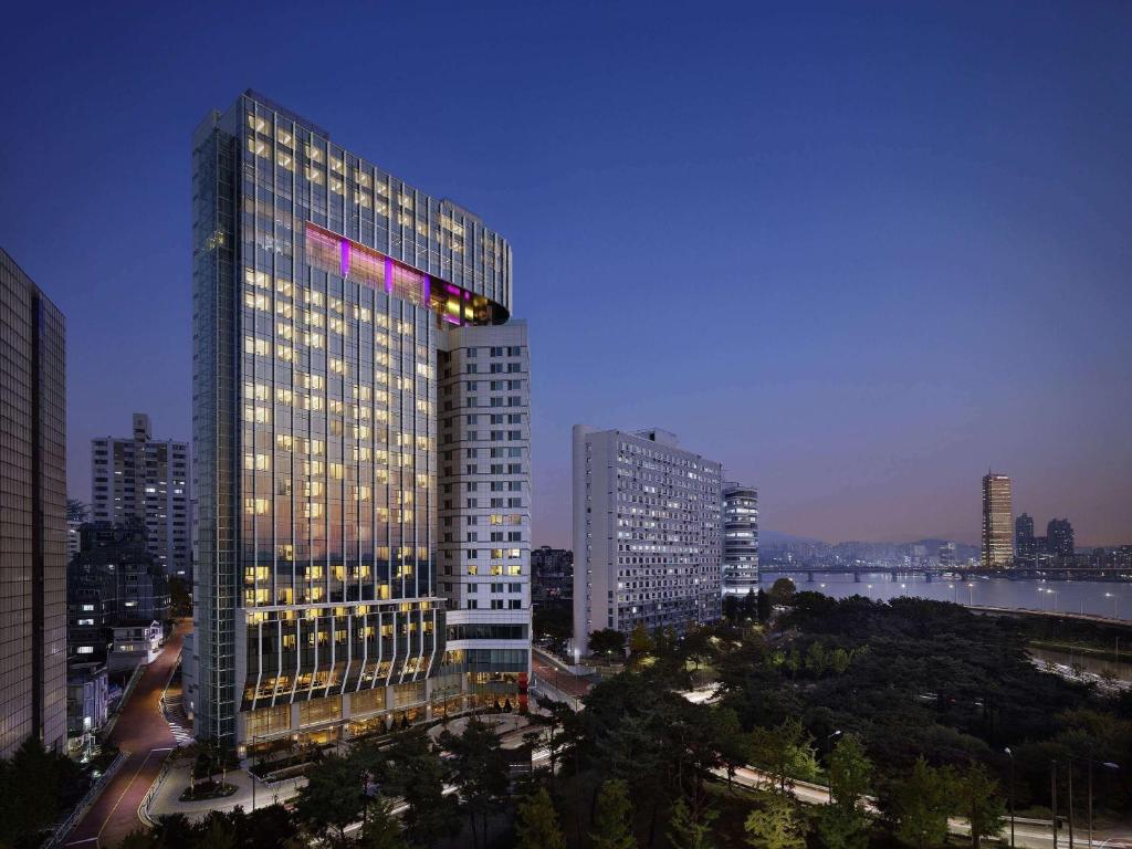 Hotel Naru Seoul MGallery Ambassador في سول: مبنى طويل وبه أضواء عليه في مدينة