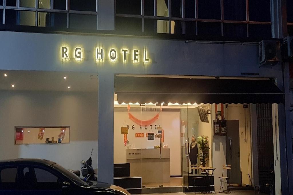 a hotel with a sign on the side of a building at RG Hotel in Air Hitam