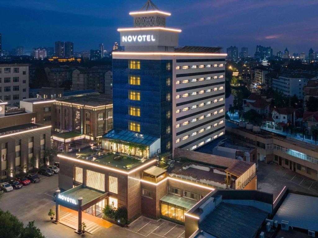 a large building with a sign on top of it at Novotel Nantong Center in Nantong