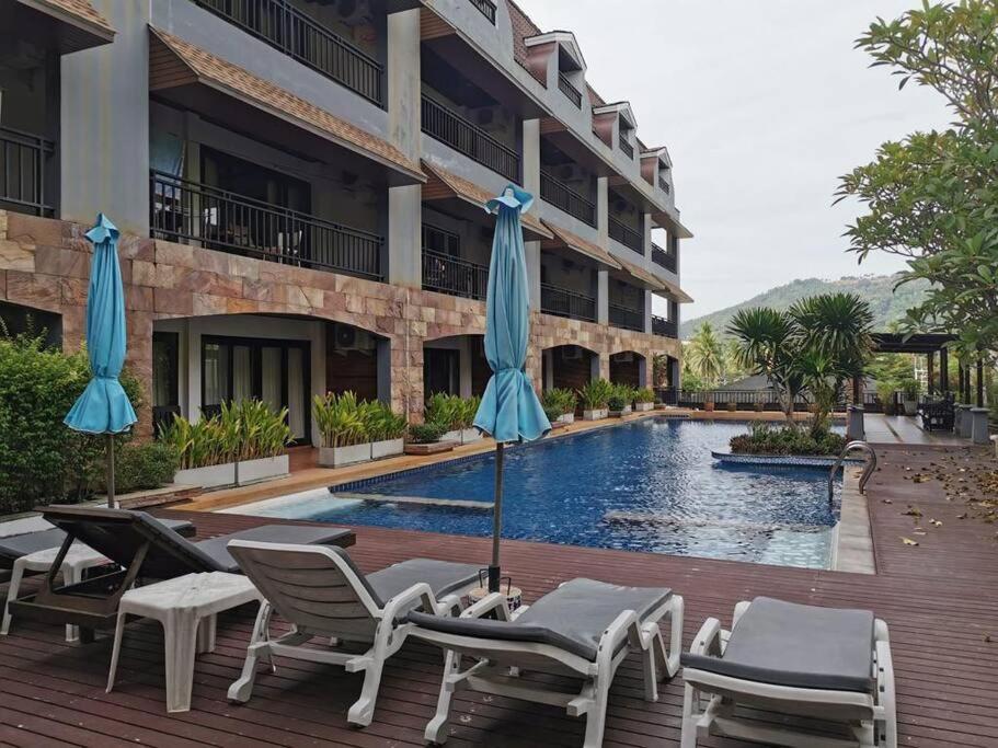 een hotel met een zwembad met stoelen en parasols bij DD Condominium in Ban Khlong Mae Nam