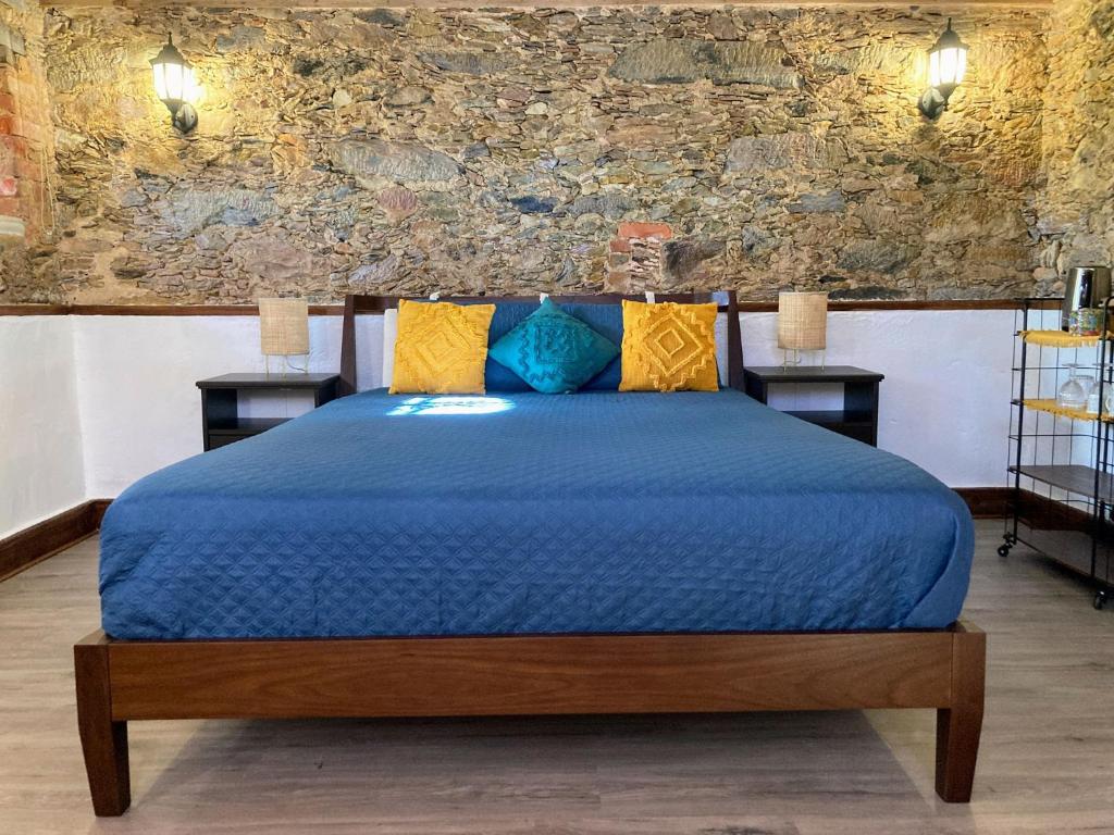 a bedroom with a blue bed with two night stands at A Casa Amarela Guest room in São Martinho da Cortiça