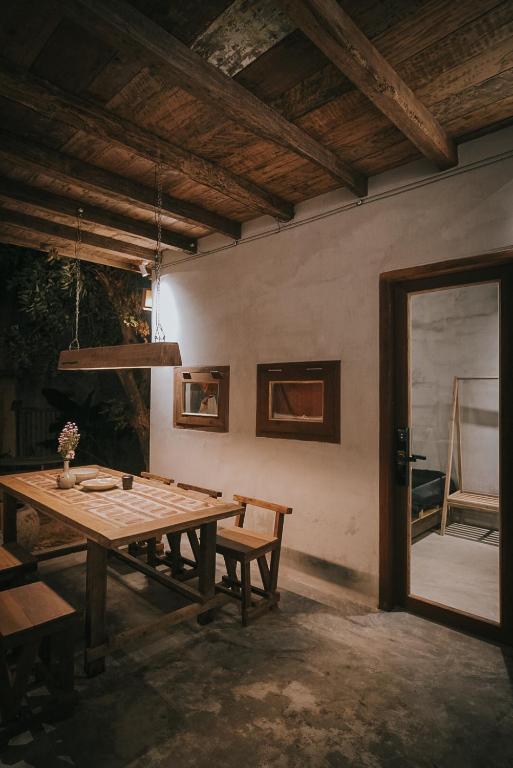 a dining room with a wooden table and a window at Thoai Mai House Phan Thiết in Ấp Bình Hưng