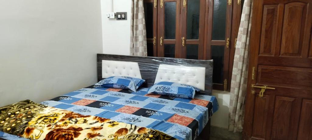 a bedroom with a bed with a blue comforter at Harman paying guest house in Ayodhya