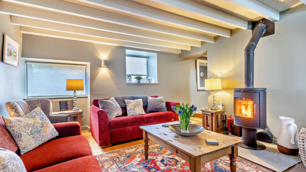 a living room with a couch and a wood stove at Hillcrest Barn in Monyash