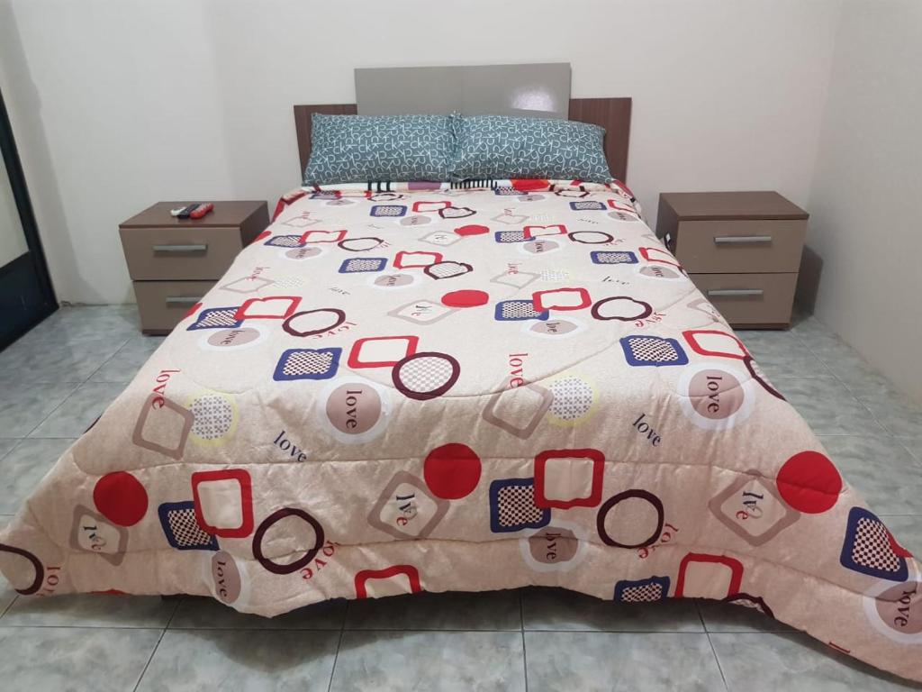 a bed with a comforter with glasses on it at Rento Suite amoblada al norte de Machala in Machala