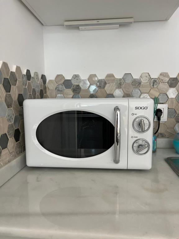 - un four micro-ondes blanc sur un comptoir dans la cuisine dans l'établissement Garden-Goretti House, à Mairena del Aljarafe