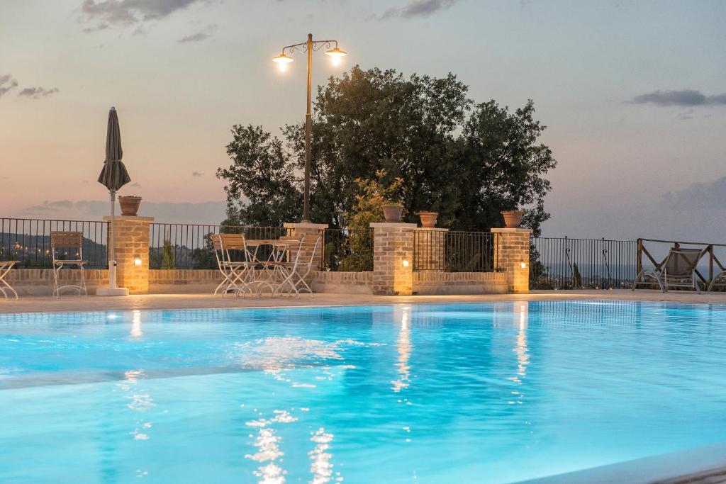 a large swimming pool with a light pole and chairs at Villa Sant'Angelo in Alba Adriatica