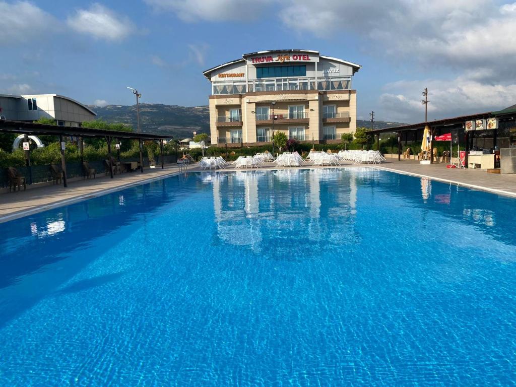 a large blue swimming pool in front of a building at Truva Life Hotel in Samandağı