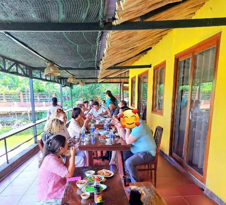 eine Gruppe von Menschen, die an einem Tisch in einem Restaurant sitzen in der Unterkunft TINA LAKESIDE PHUOC HAI (5 minutes from beach) in Chợ Phước Hải
