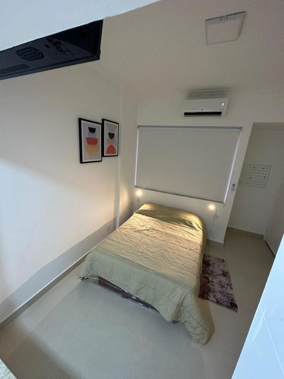 Cama pequeña en habitación con pared blanca en Apartamento en Río de Janeiro