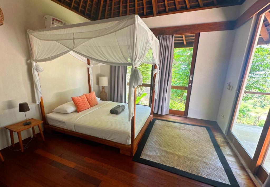 a bedroom with a bed with a canopy at Villa Sorgas in Kuta Lombok
