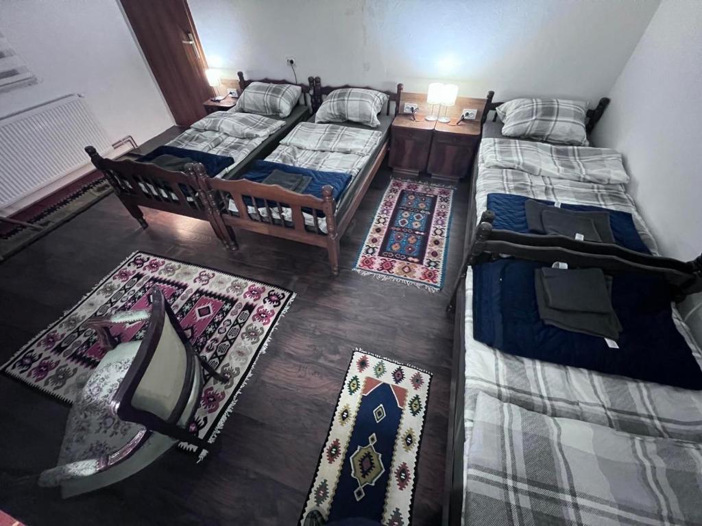 two beds in a room with two rugs at Prenoćište Jocic in Pirot