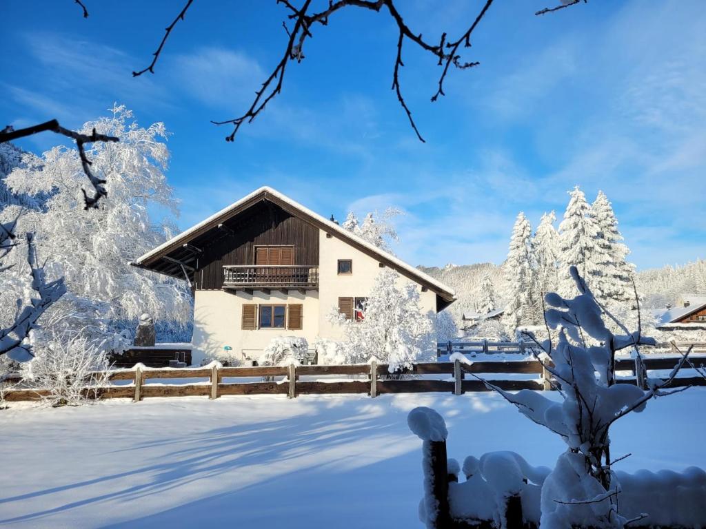 een huis in de sneeuw met bomen bij Am Ampferang:Ferienhaus in Ettal in Ettal