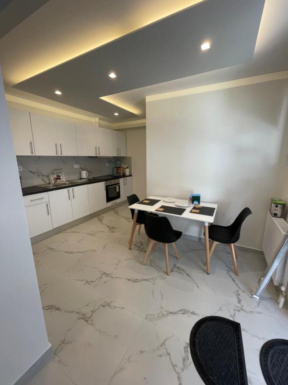 a kitchen with a table and chairs on a marble floor at Alexandra apartment in Athens