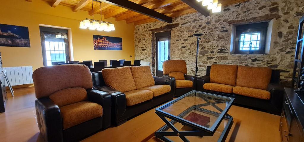 sala de estar con muebles de cuero y mesa en El Almendro del Cura en Villarmayor
