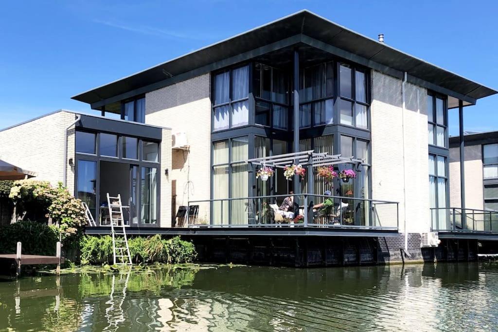 een gebouw met een balkon naast een waterlichaam bij Prachtig guesthouse aan het water in Almere