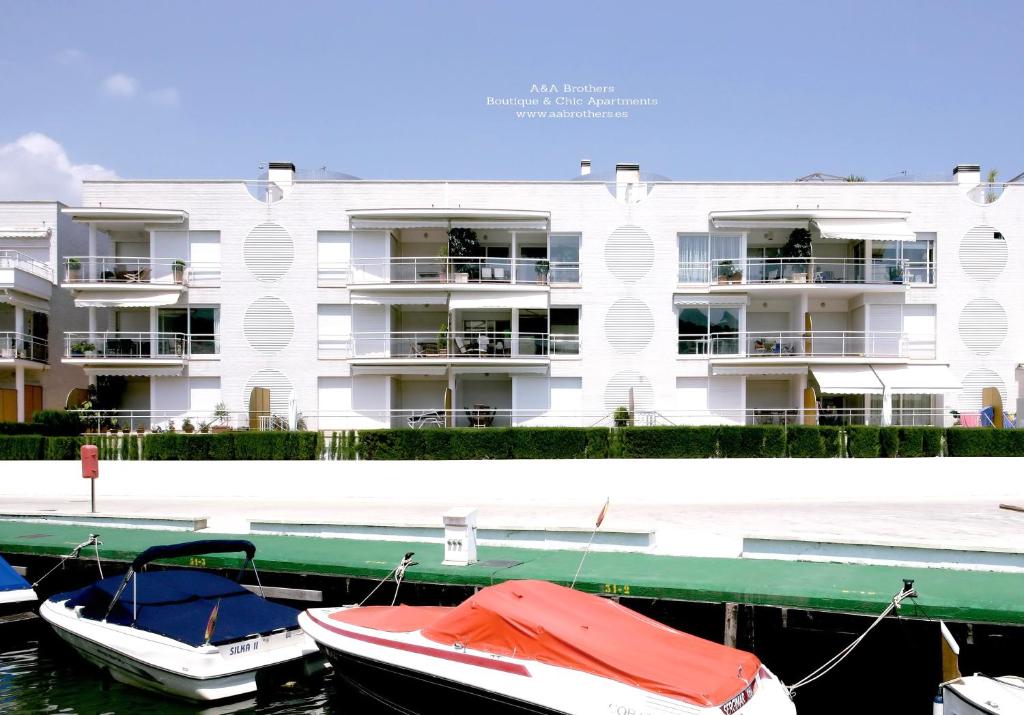 un edificio con barche ormeggiate di fronte a un porto turistico di A&A Brothers Port d'Aro a Platja  d'Aro